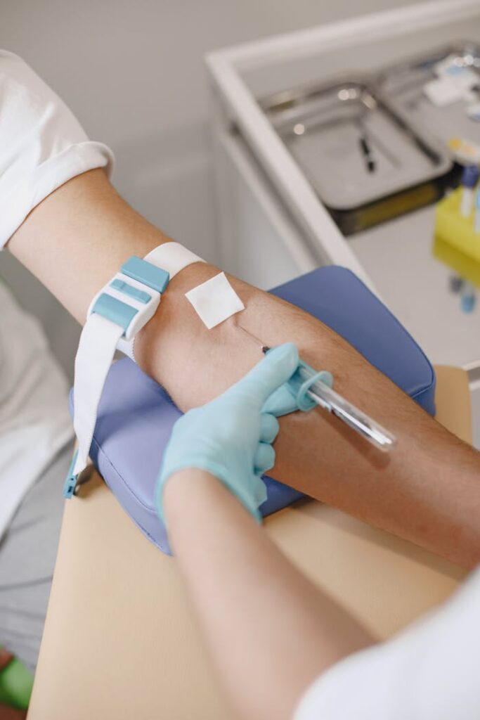 Close-up of a medical professional performing a blood draw with precision and care in a clinical setting.